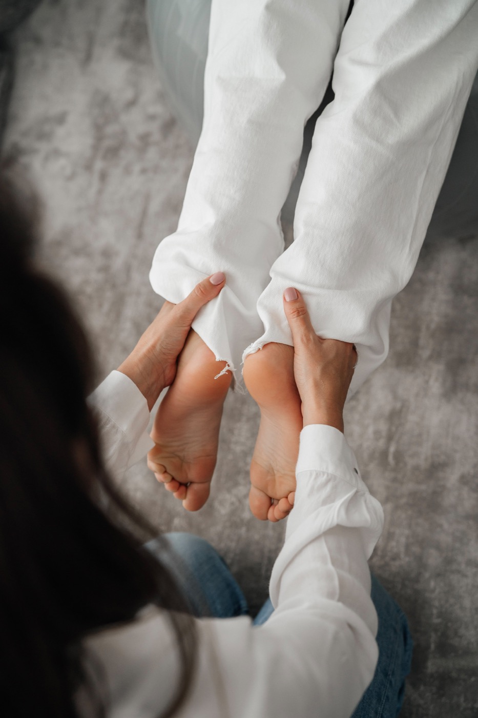 Hands supporting a child's feet during movement work